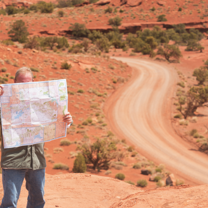 Man looking at a map on a desert road